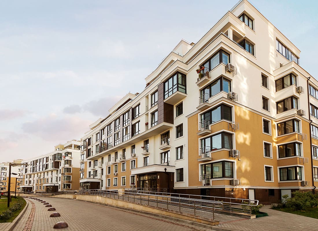 Contact - Modern Urban Condo Buildings with a Walkway Against a Cloudy Sky in the Late Afternoon